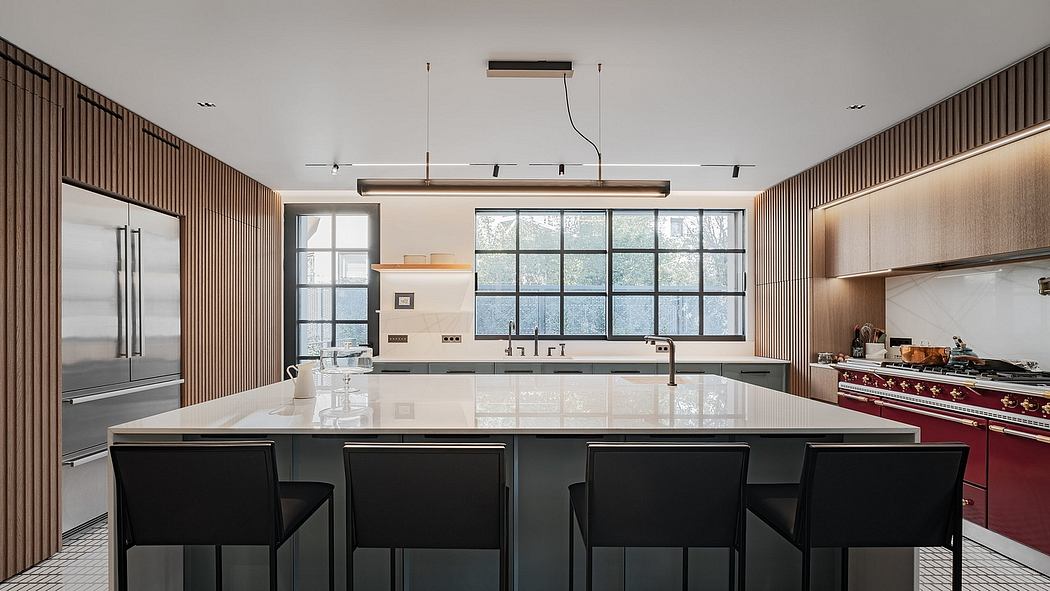A modern, open-concept kitchen with sleek wood paneling, large windows, and a central island.