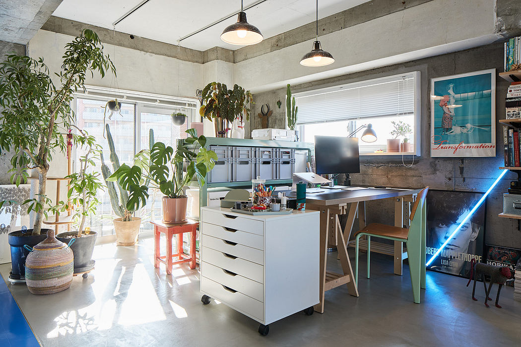 Spacious, modern workspace with concrete walls, plants, and vibrant lighting fixtures.