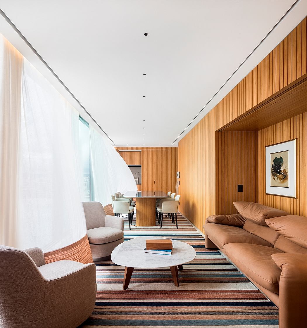 Modernist living area with warm wood paneling, striped rug, and clean lines.