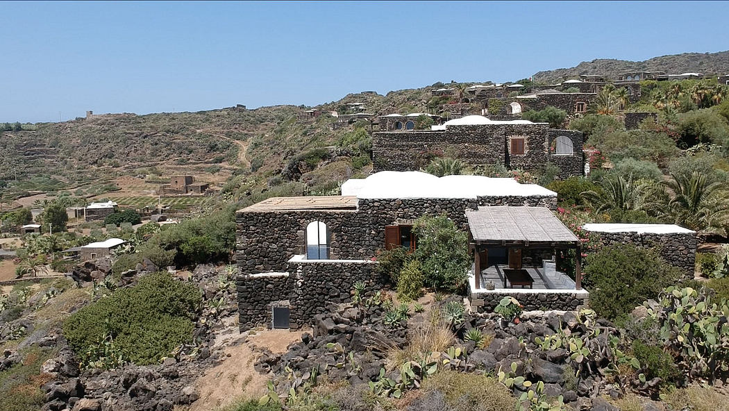 A picturesque village in a mountainous, arid terrain, featuring traditional stone dwellings.
