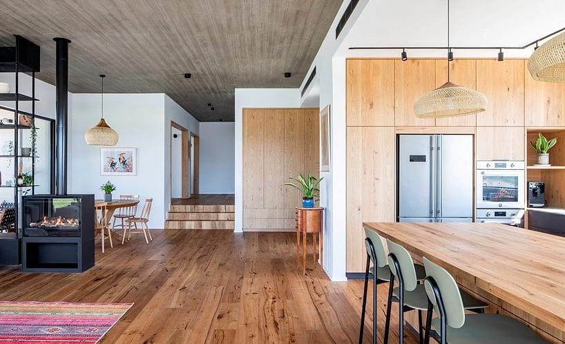 Warm, modern interior with wood flooring, open concept, and sleek kitchen appliances.