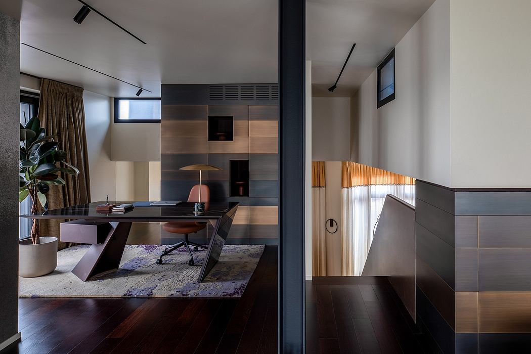 Sleek, modern home office with wooden accent panels, black furnishings, and a colorful area rug.