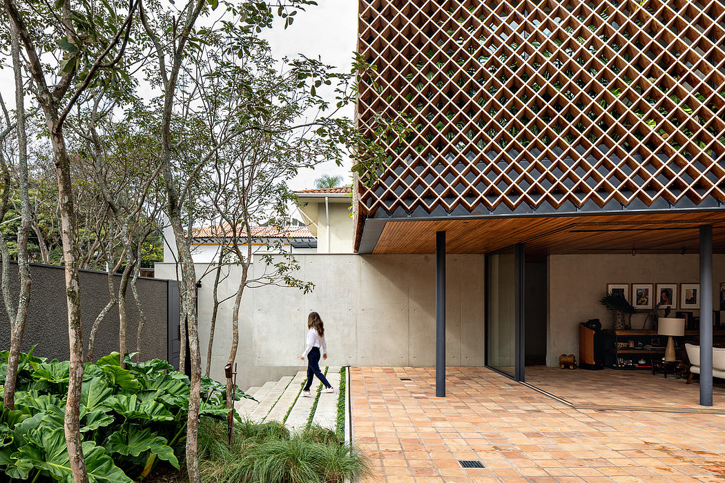 A contemporary home with a tiled patio, latticed overhang, and lush surrounding vegetation.