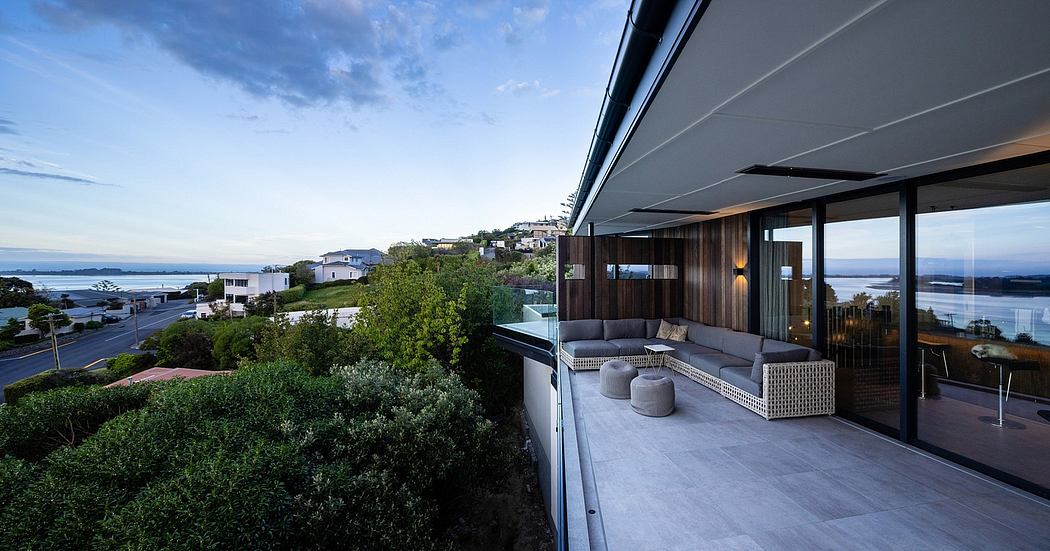 Sleek modern terrace with panoramic views and cozy furniture overlooking a cityscape.