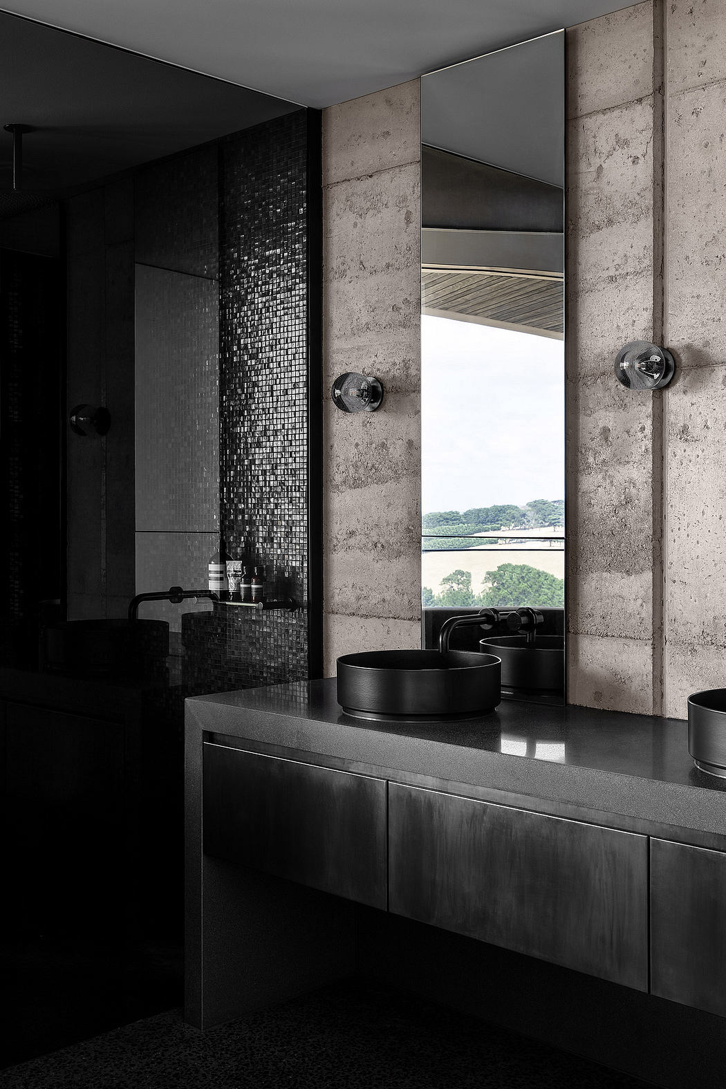 Sleek, minimalist bathroom with concrete walls, mosaic tile, and black vessel sinks.