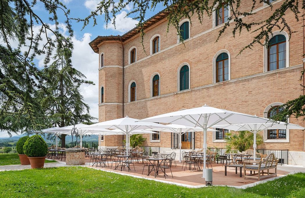 A picturesque Italian villa with terracotta-tiled roofs, ornate arched windows, and a charming outdoor seating area.
