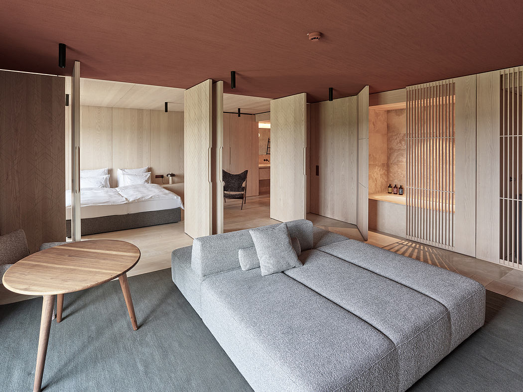 Minimalist bedroom with sliding doors, built-in shelves, and a cozy gray sofa.