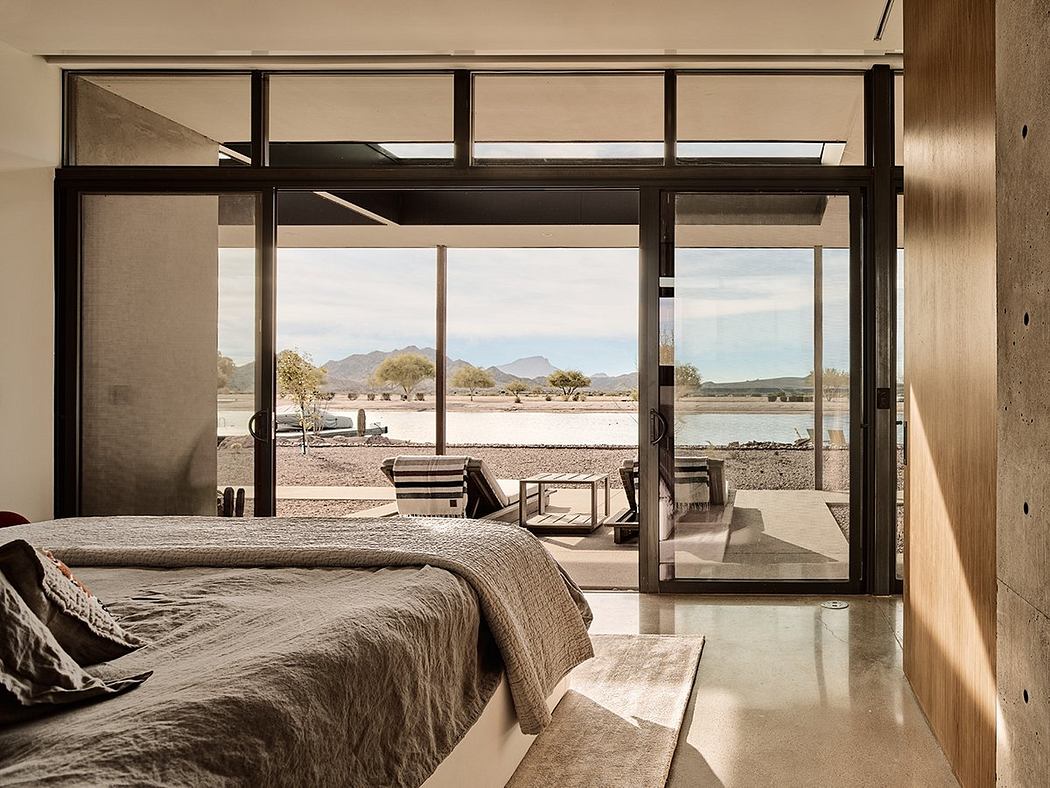 Expansive desert landscape framed by sleek glass and metal architecture.