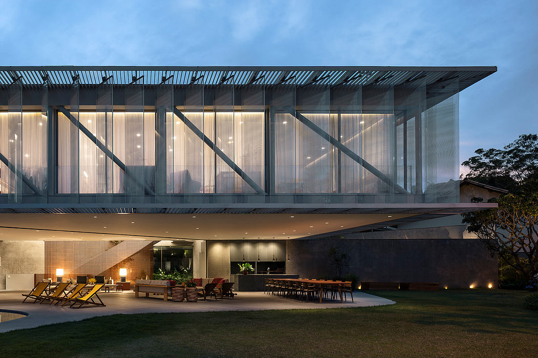 Sleek glass-walled structure with overhead metal canopy, outdoor lounge area below.