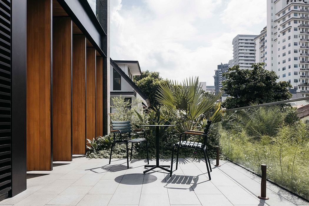 Sleek modern architecture with lush greenery, outdoor seating area, and city skyline.