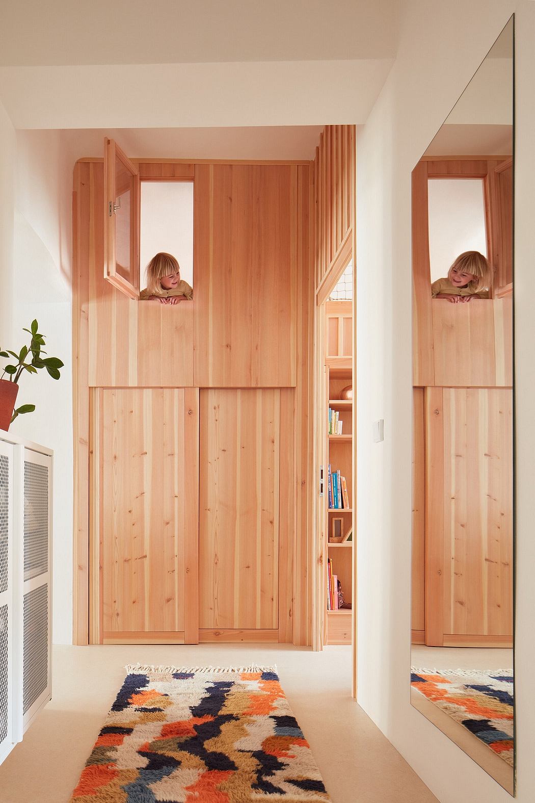 A cozy wooden alcove with built-in shelving and mirrors, accentuating the warm, modern design.