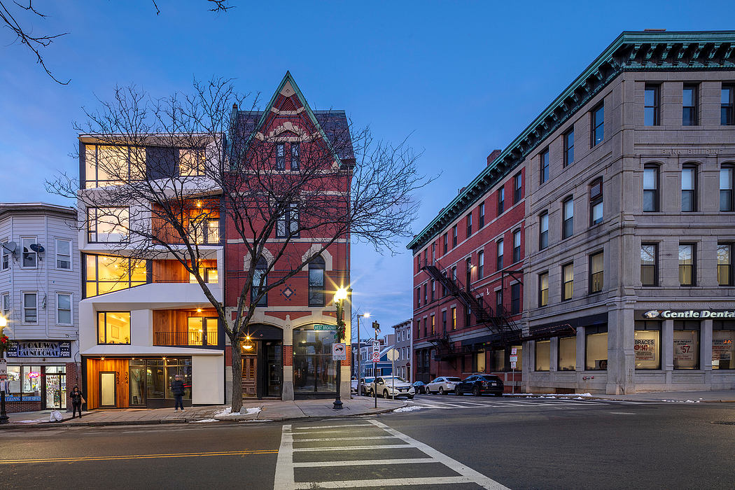 Ornate 19th-century commercial buildings with illuminated windows and pedestrian crosswalk.