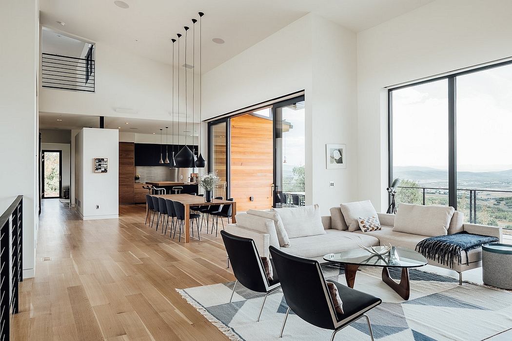 Open-concept living area with modern furniture, wooden accents, and expansive windows offering scenic views.