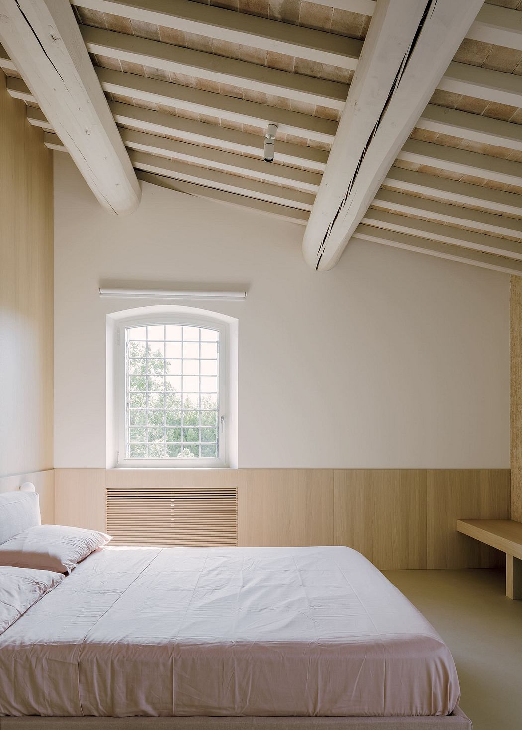 Rustic wood beam ceiling, arched window, minimalist bedroom design.