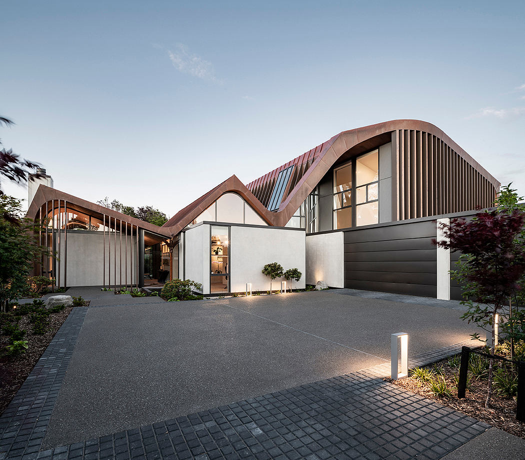 Modern architectural masterpiece with distinctive roofline, glass facade, and landscaped driveway.
