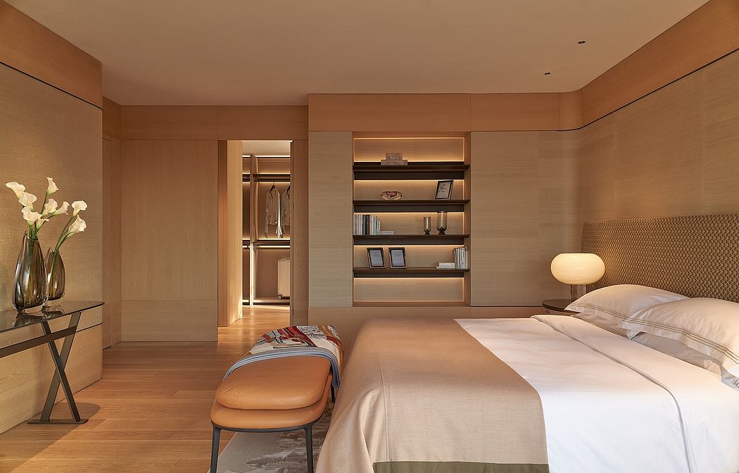 Warm, wood-paneled bedroom with built-in shelving, cozy chair, and minimalist decor.