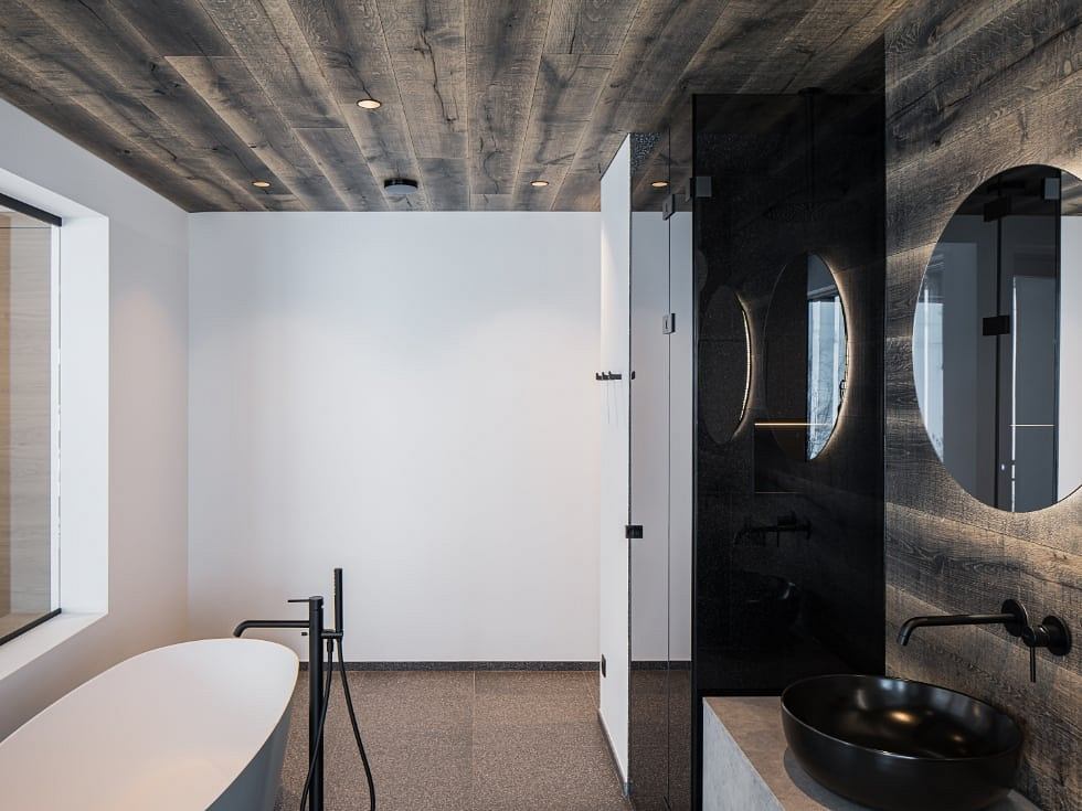 Rustic concrete ceiling, round mirror, black fixtures, and minimalist design elements.