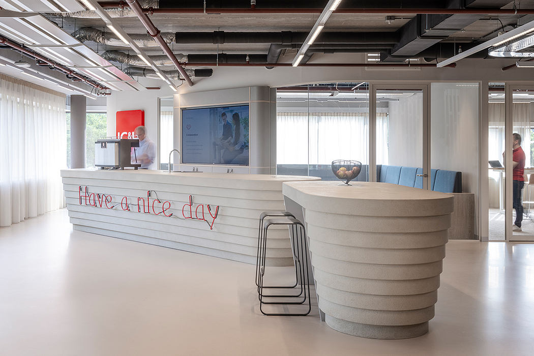 Contemporary open-plan office space with modular furniture, large windows, and bold wall graphics.