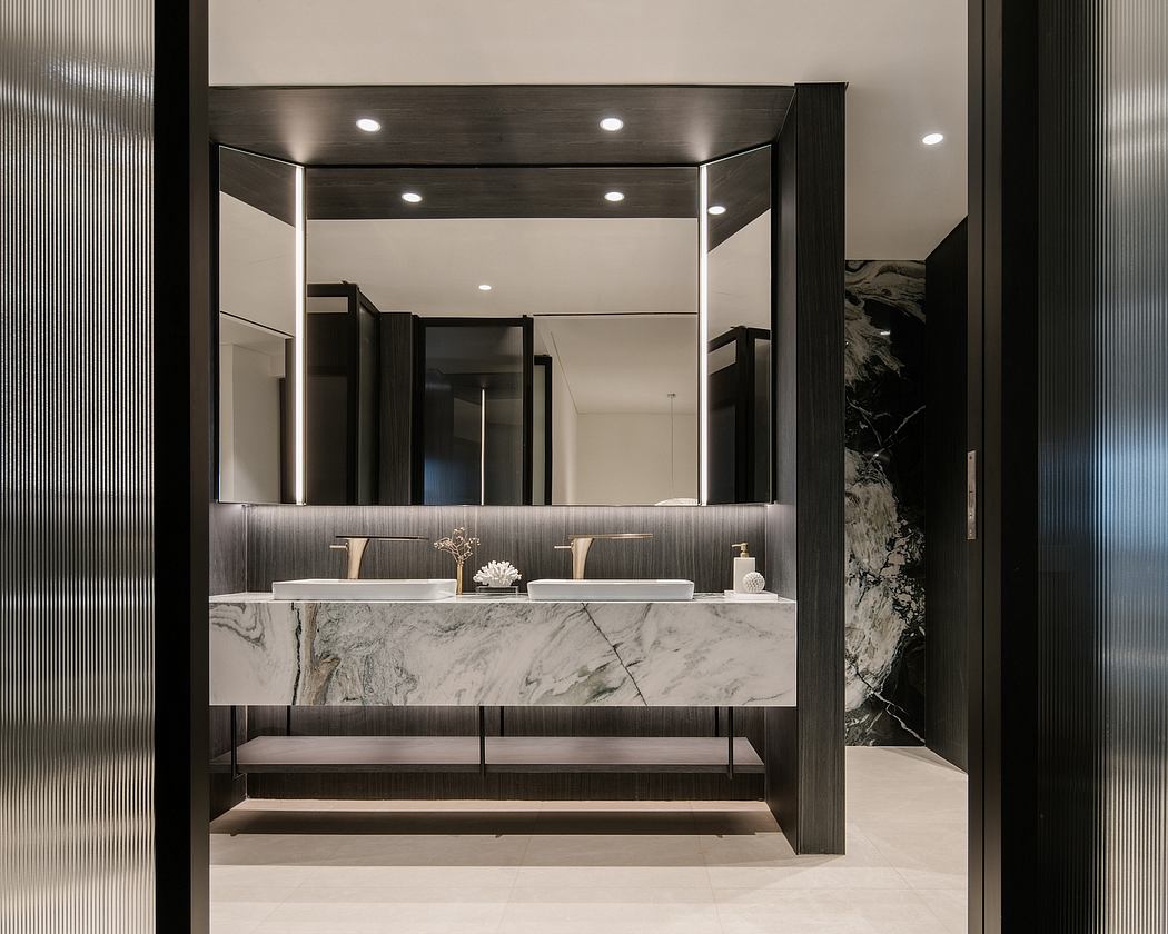 Luxurious bathroom with sleek, modern design featuring marble countertops and mirrored vanity.