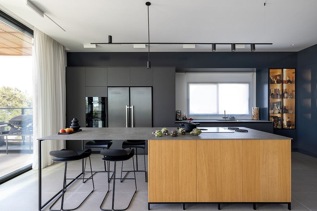 Contemporary kitchen with sleek black cabinetry, integrated appliances, and wooden island.