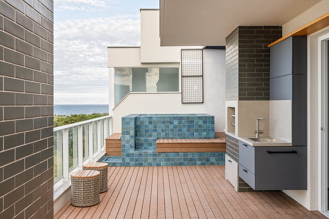 Sleek, modern outdoor kitchen with tiled steps, wooden deck, and expansive ocean view.