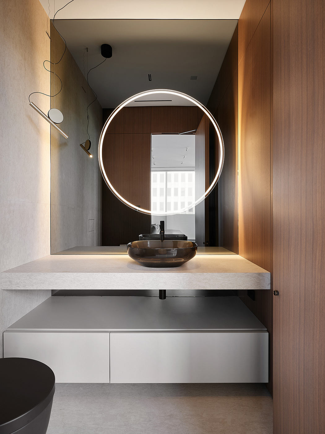 A modern bathroom with a circular lighted mirror, wooden vanity, and minimalist design.