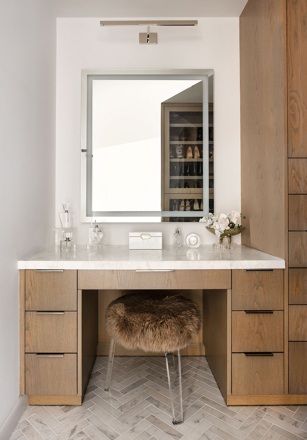 Sleek modern vanity with white countertop, wood drawers, and plush furry stool.