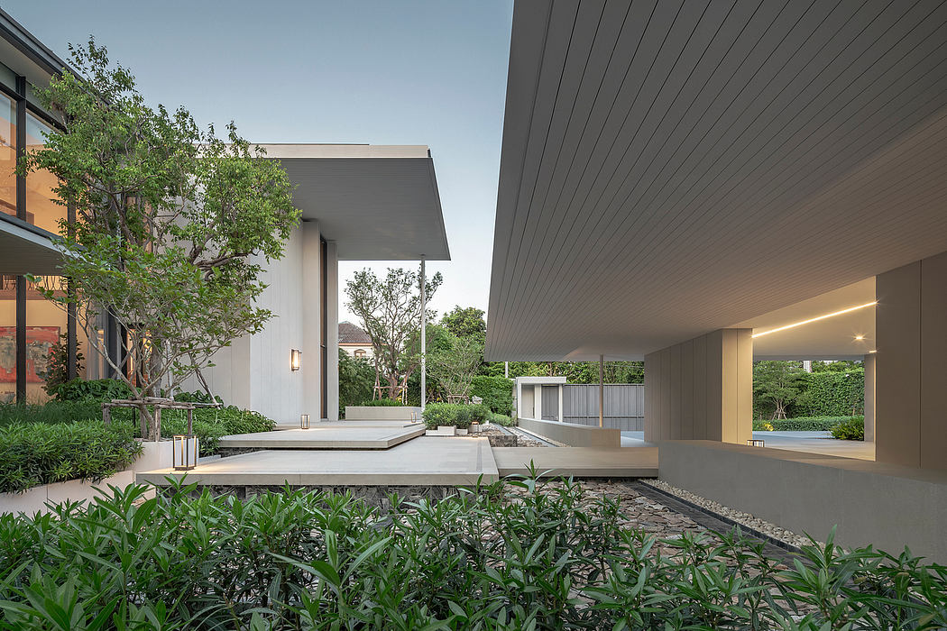 Minimalist architectural exterior with patio, greenery, and indirect lighting.