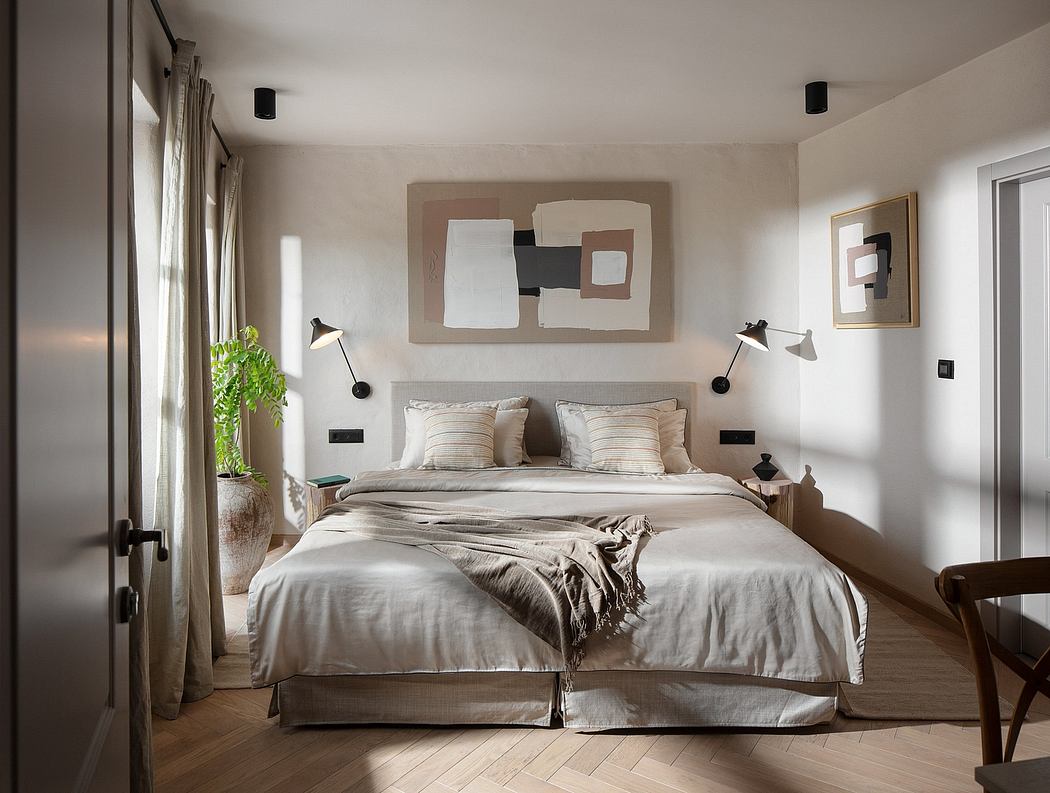 Minimalist bedroom with neutral tones, modern artwork, and warm hardwood flooring.