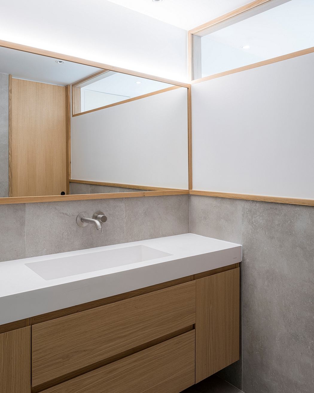 A minimalist bathroom with modern wooden cabinetry, sleek vanity, and recessed lighting.