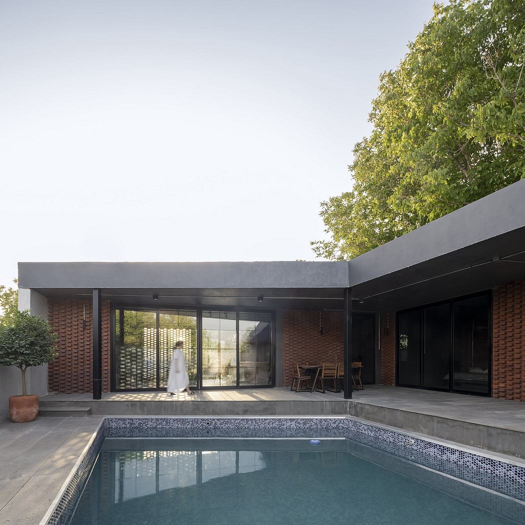 A modern brick house with a sleek concrete roof, large glass windows, and a swimming pool.