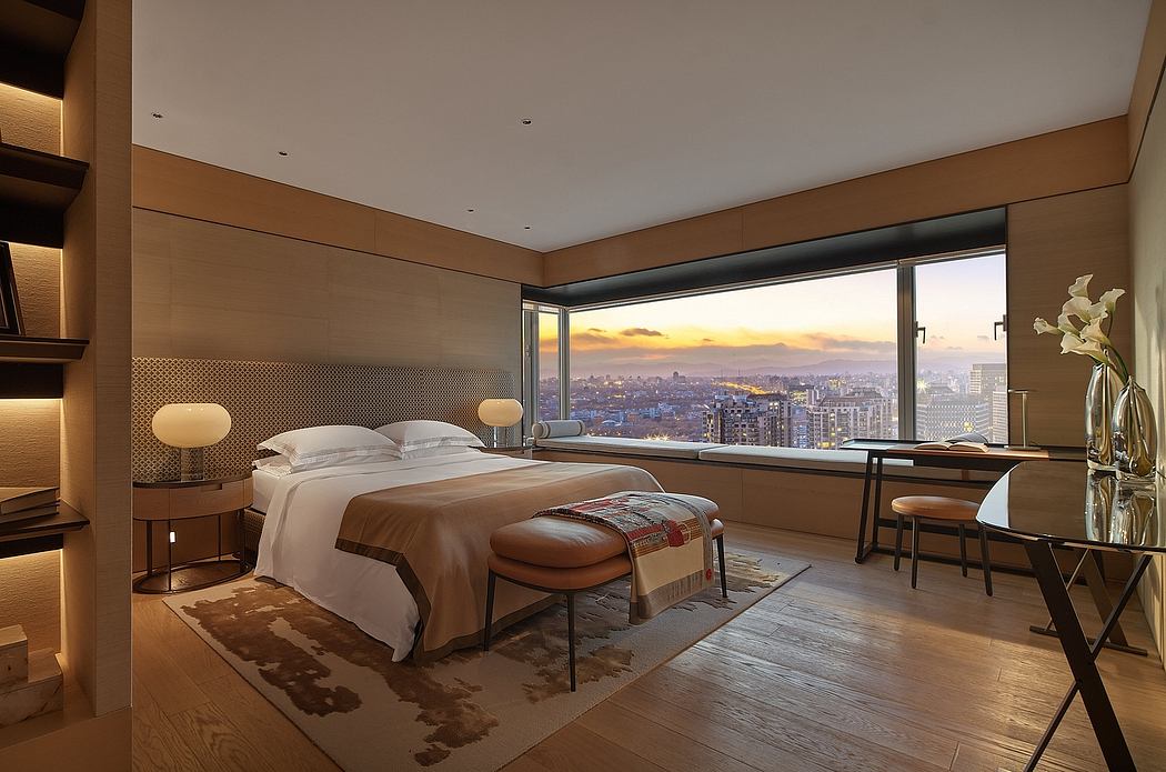 Spacious modern bedroom with stunning city skyline view, sleek furnishings, and warm lighting.