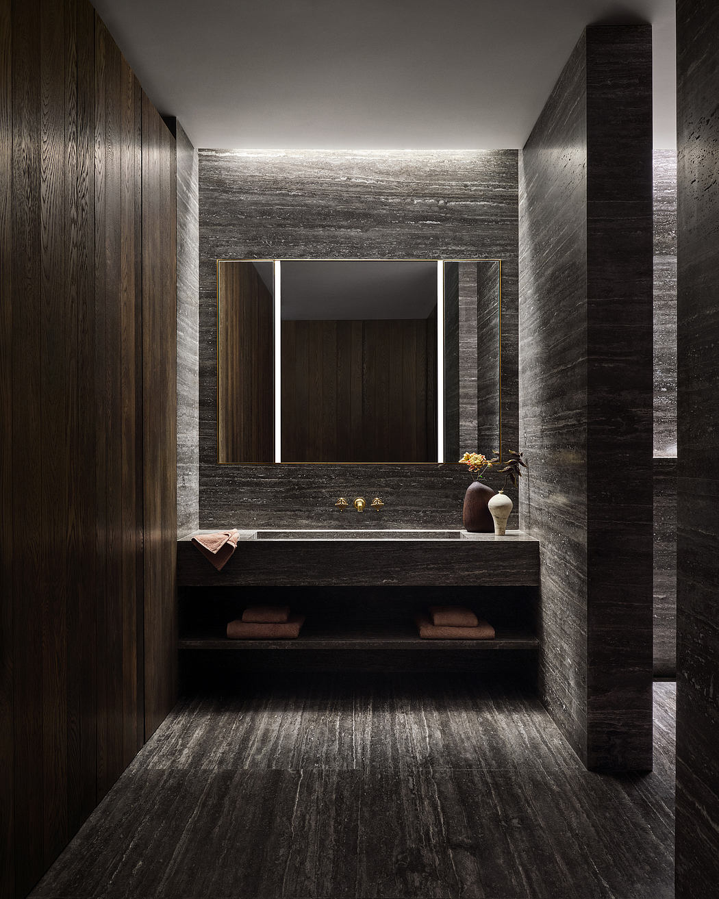 A sleek, minimalist bathroom with dark, textured walls, a simple vanity, and a large mirror.