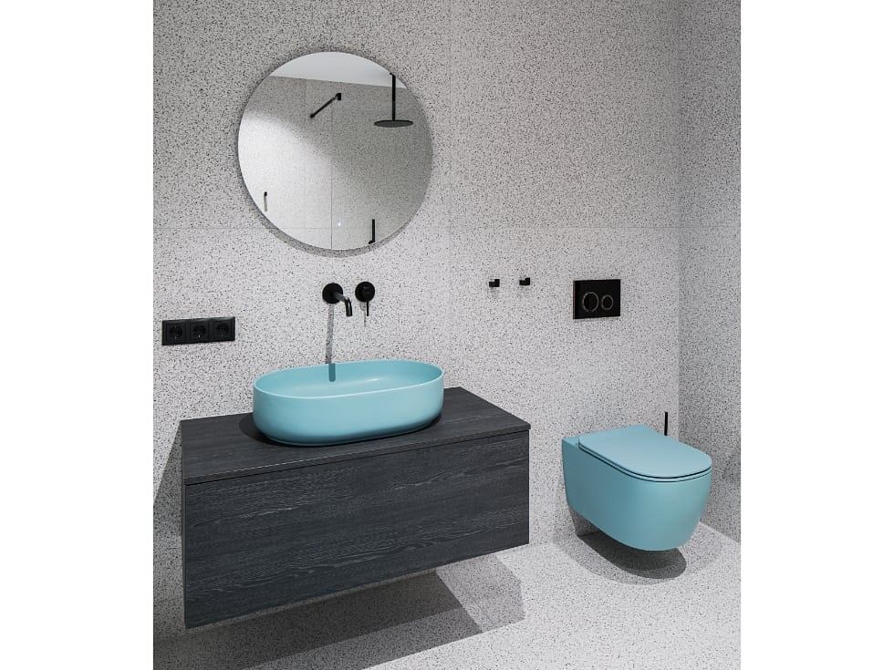 Sleek modern bathroom design with turquoise vessel sink, wall-mounted vanity, and toilet.