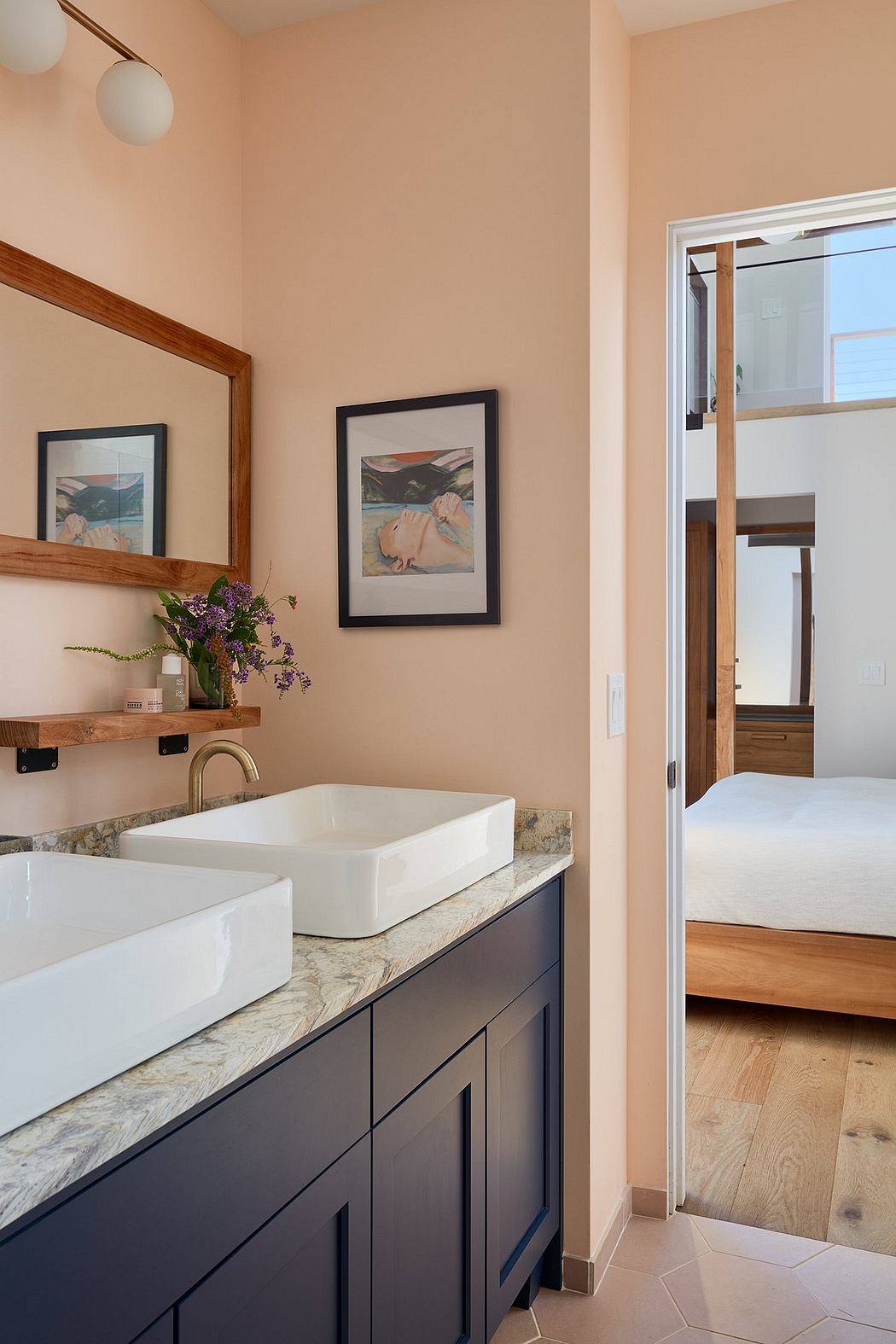 Spacious bathroom with double vanity, wooden shelves, and framed artwork.
