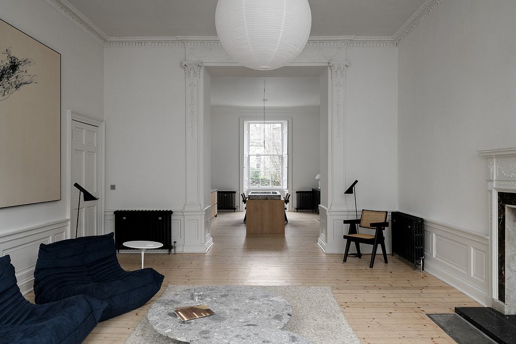 A spacious, modern room with tall windows, a fireplace, and minimalist furniture.