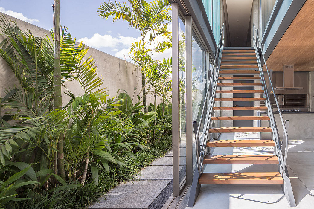 Sleek, modern stairs with tropical foliage provide an inviting entrance to the building.