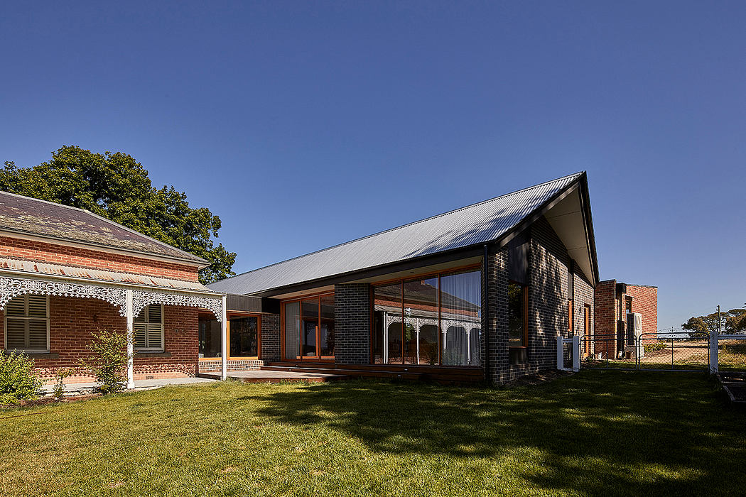 Expansive brick building with large windows, porches, and peaked metal roofs.