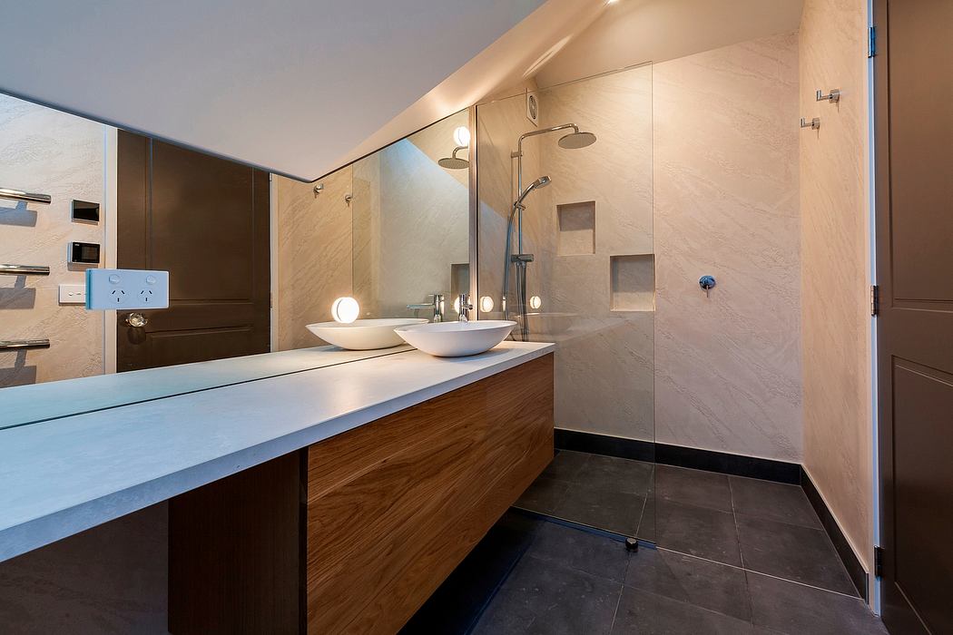 A modern, well-designed bathroom with a sleek vanity, vessel sinks, and glass shower enclosure.