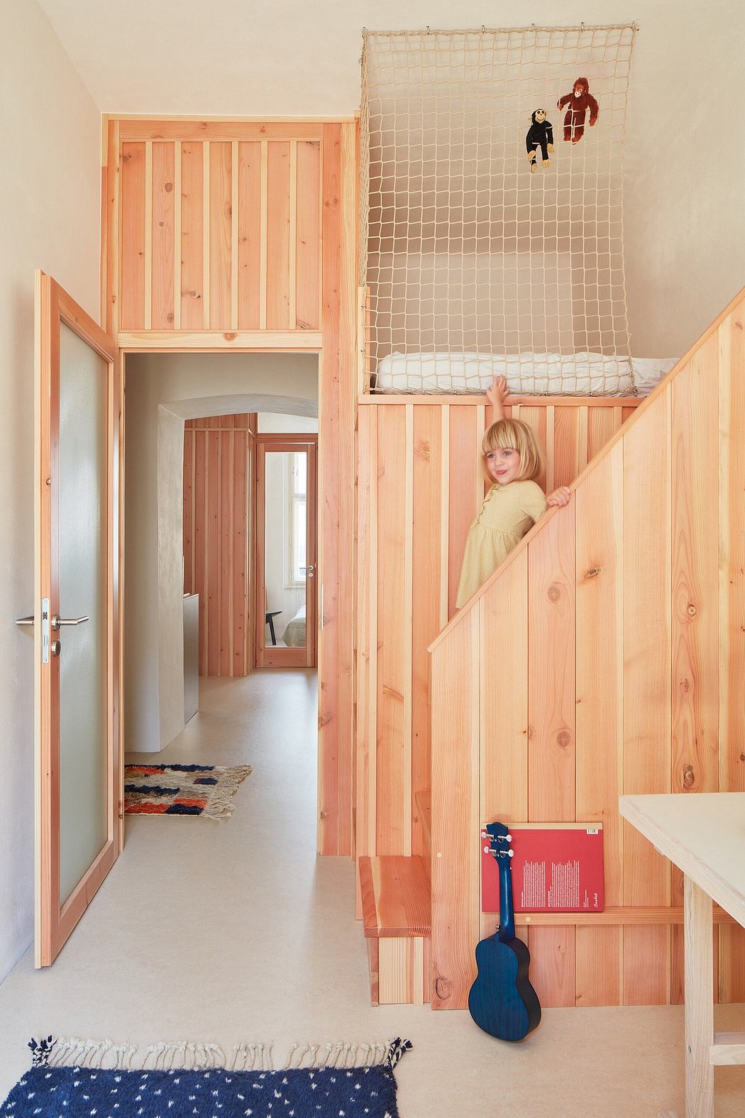 Cozy wooden interior with playful net, guitar, and child's bedroom atmosphere.