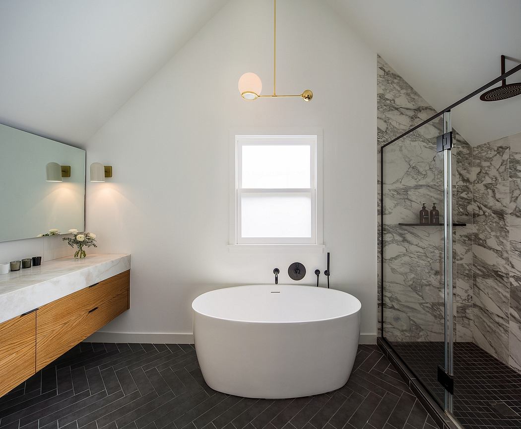 Elegant bathroom with large marbled wall, freestanding tub, and minimalist fixtures.