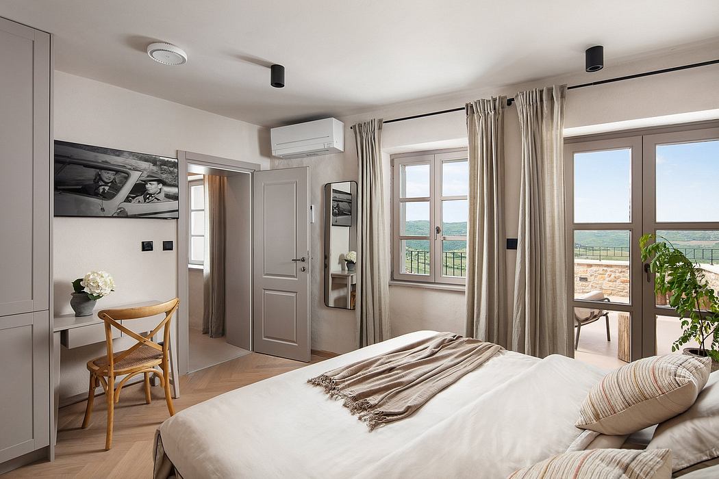 Spacious bedroom with large windows, neutral color scheme, and modern interior design.