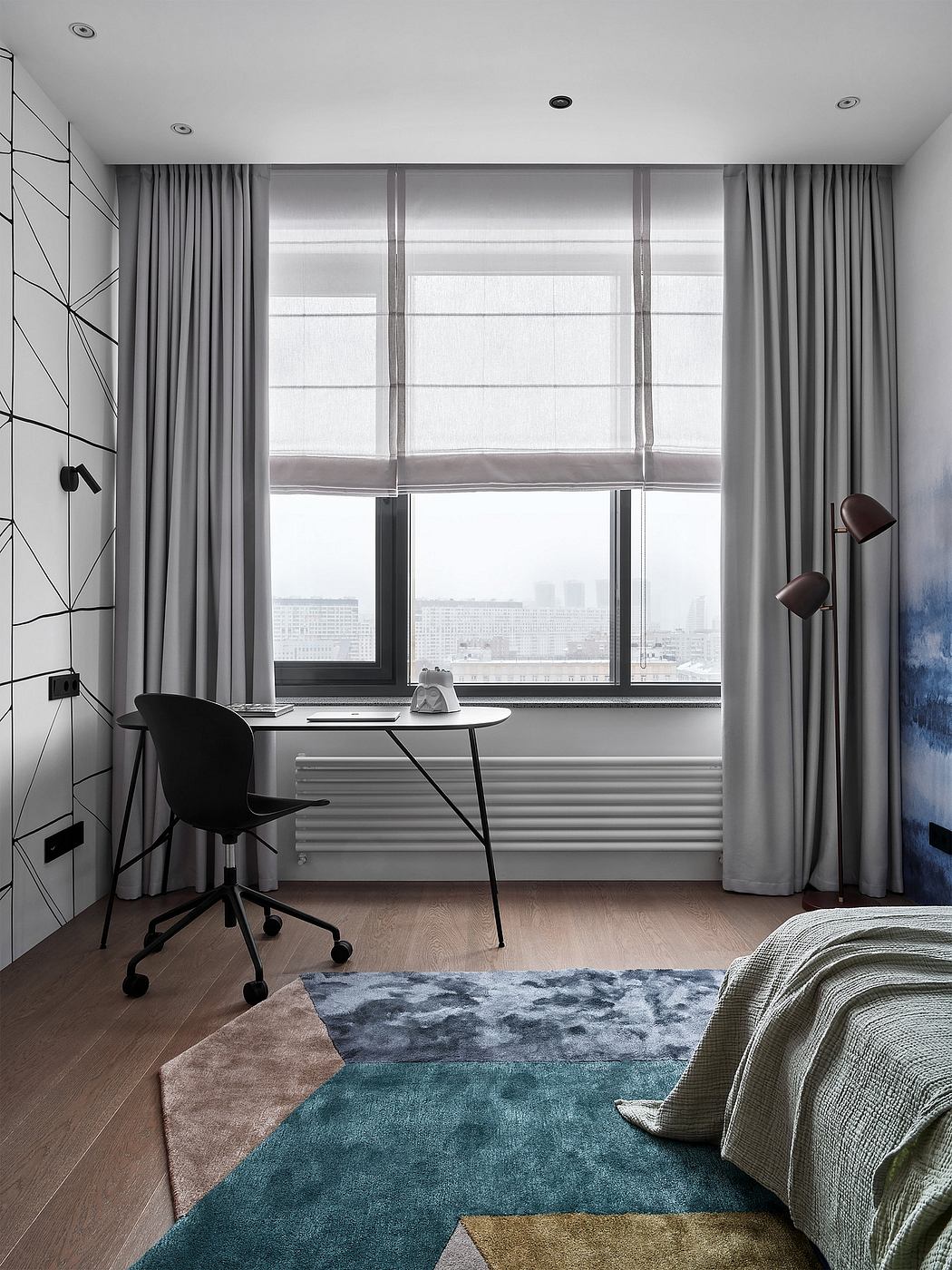 Modern minimalist bedroom with floor-to-ceiling windows overlooking the city skyline, geometric rug, and minimalist desk.