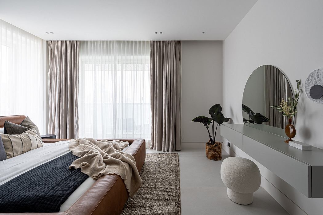 Elegant, minimalist bedroom with neutral colors, plush fabrics, and modern furnishings.