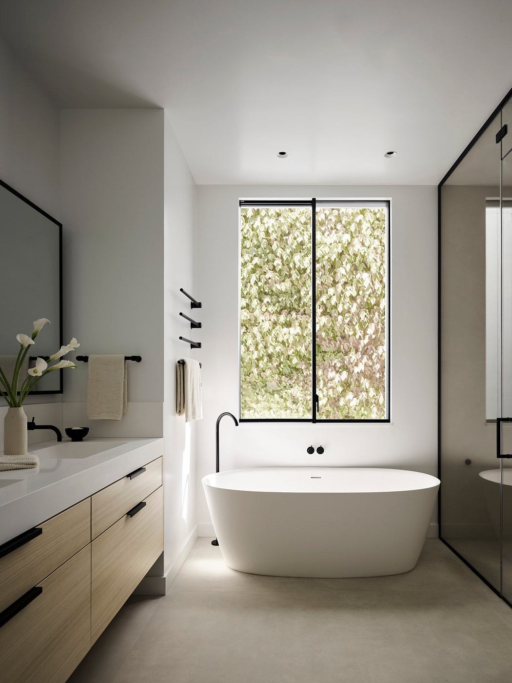 Minimalist bathroom with freestanding tub, large windows, and modern vanity.