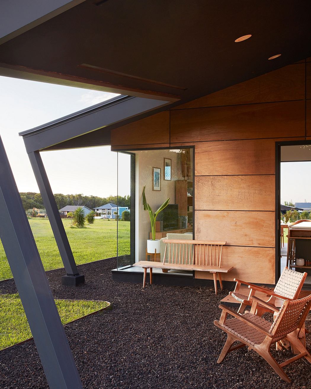 The modern design features a floor-to-ceiling glass wall, wooden panels, and a cozy seating area.