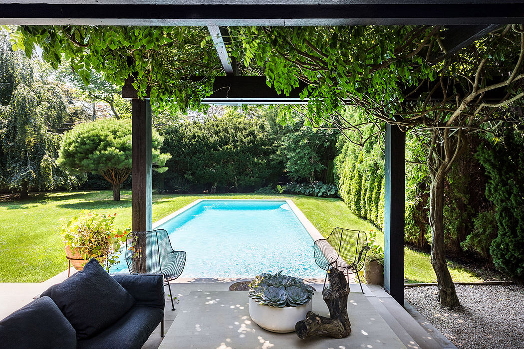 Serene backyard oasis with a pool, lush greenery, and cozy outdoor living area.