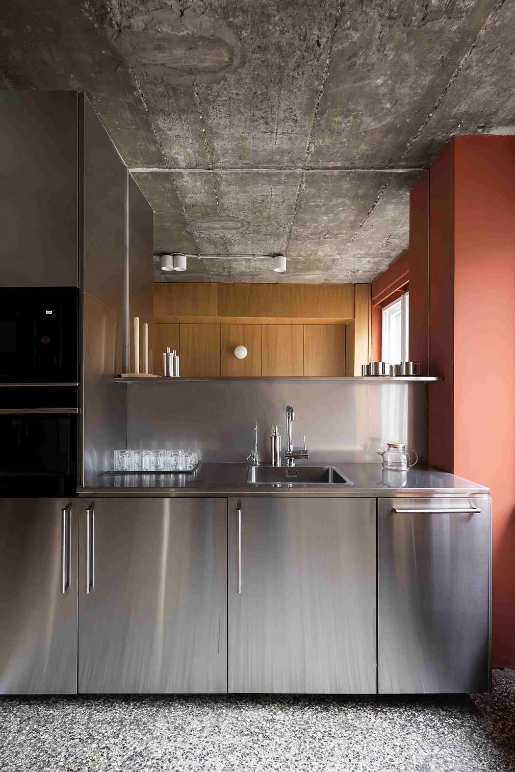 A modern kitchen with steel appliances, wooden cabinets, and a striking concrete ceiling.