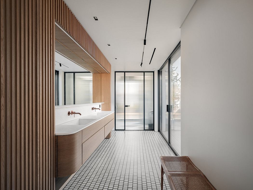 Modern bathroom with wooden paneling, floating vanity, and tile flooring leading to glass door.