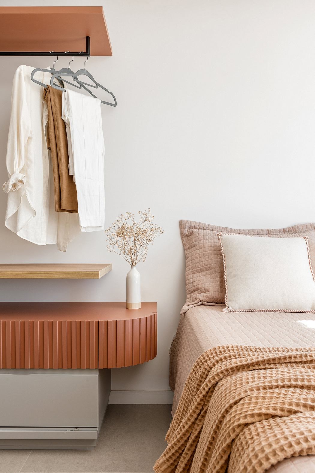 A cozy bedroom with minimalist furnishings and warm, textured accents.